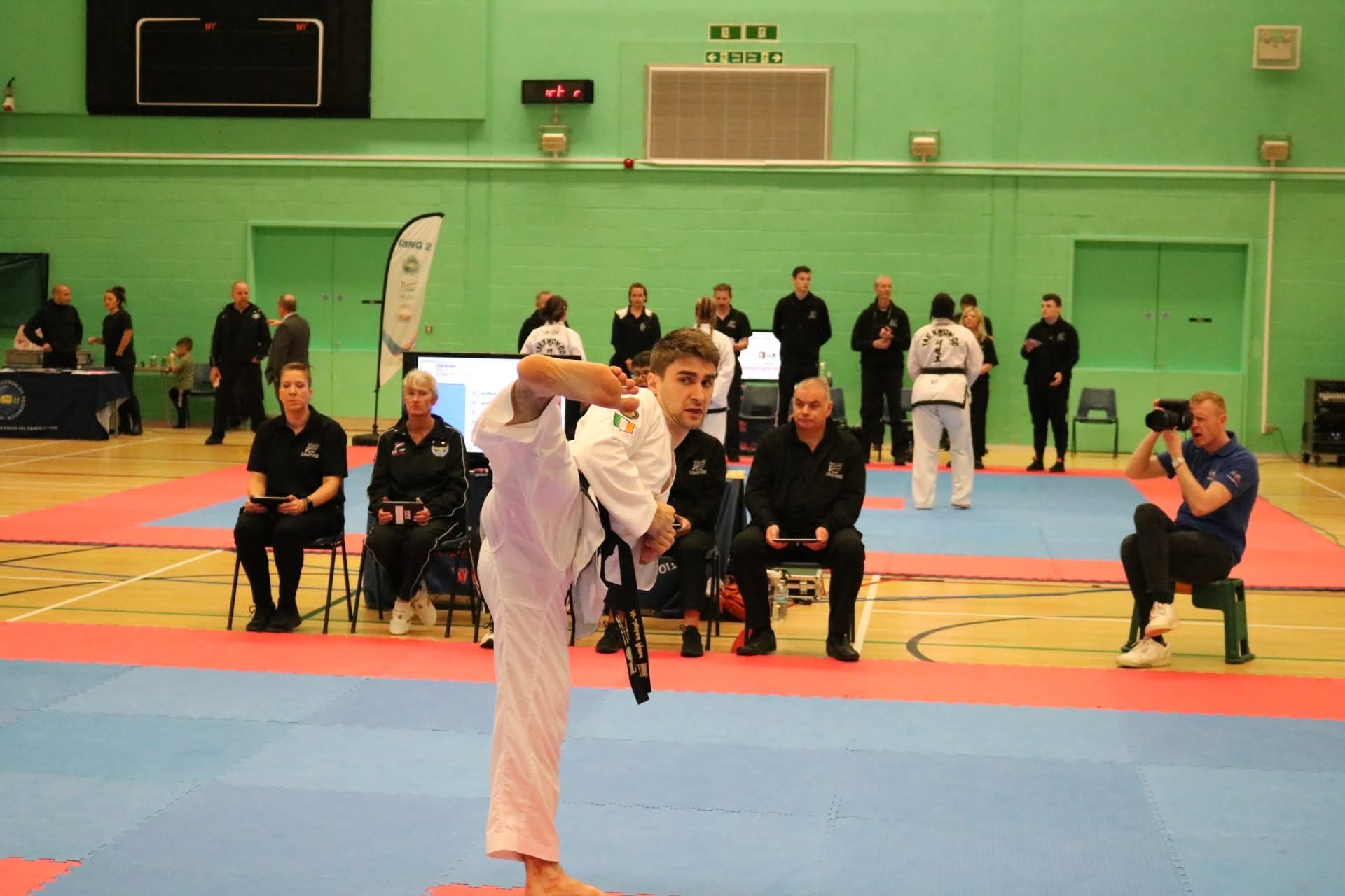 Competitor executing a high side kick in front of ITF judges